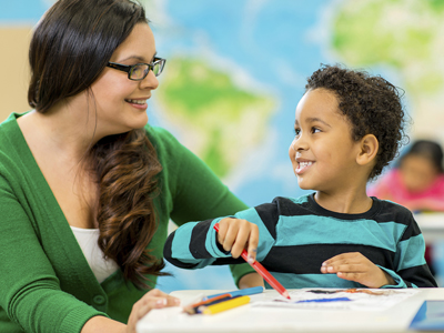 Teacher and a child at a table.