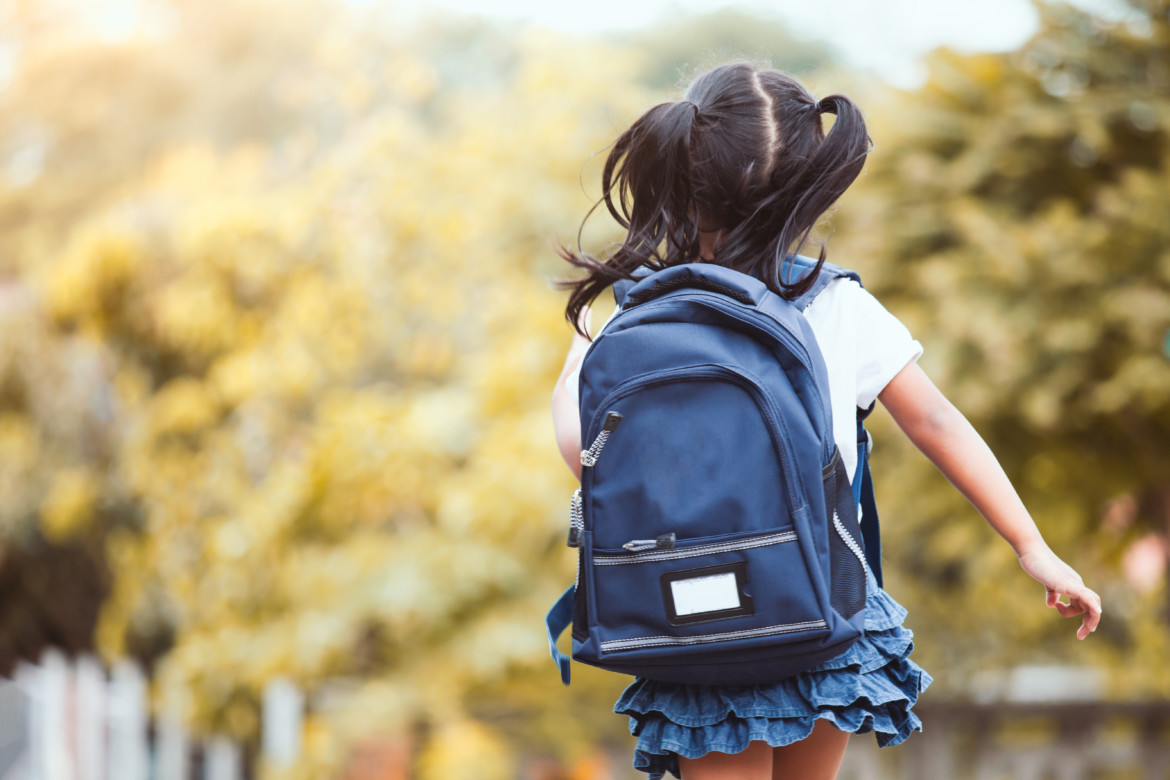 Back to school. Cute asian child girl with backpack running and going to school with fun Young girl wearing a backpack walking outside.