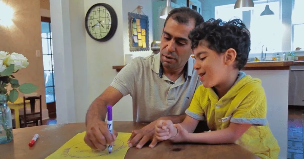 father helping son to draw at home