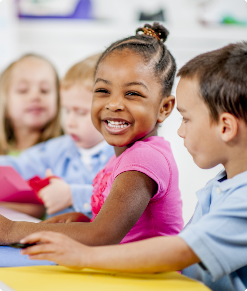 Preschool age black girl laughing in preschool class