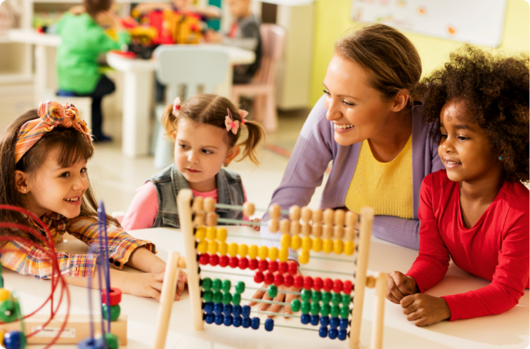teacher overlooking three happy children using an abacus