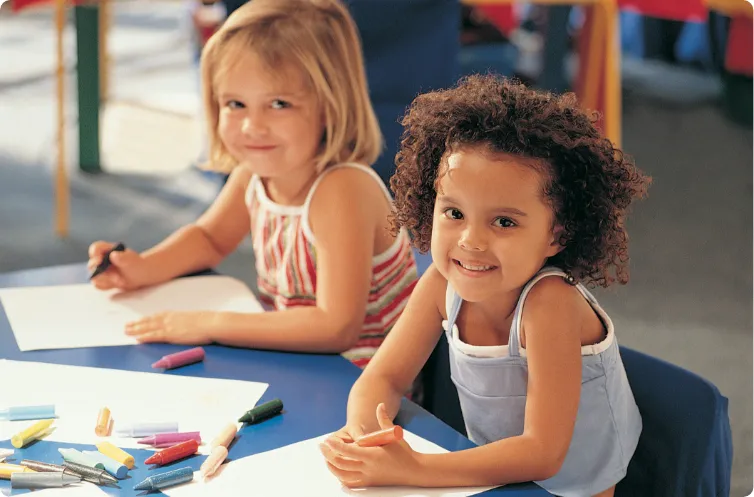 two children smiling engaged in art