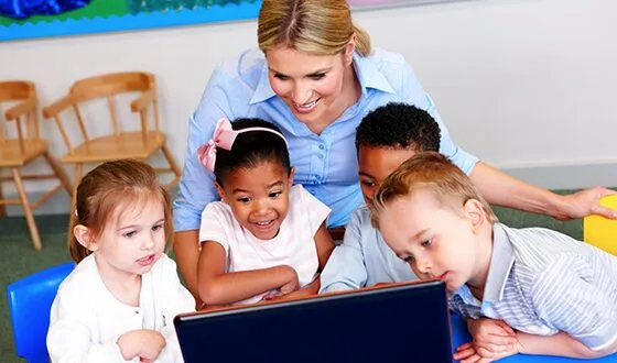 Teacher and 4 preschool children looking at a computer screen