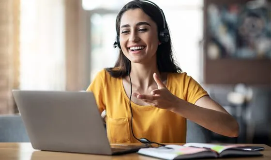 smiling woman on laptop engaged in a webinar