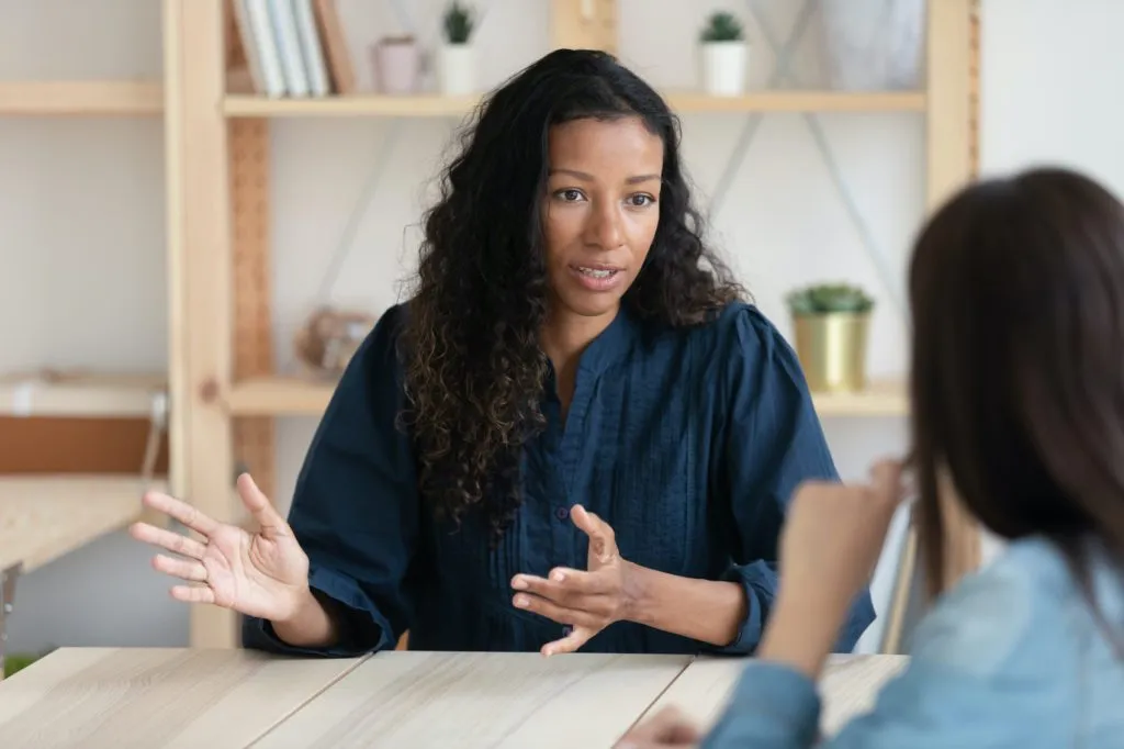 A school principal has a discussion with another adult over a table