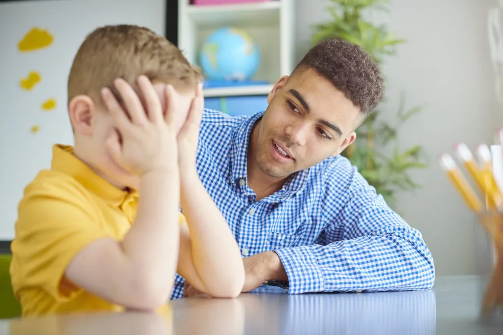 A teacher comforts a frustrated child