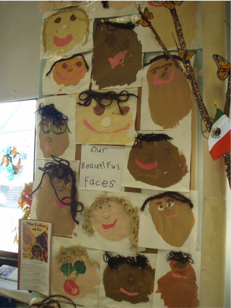Self-portraits of children are displayed in a classroom,