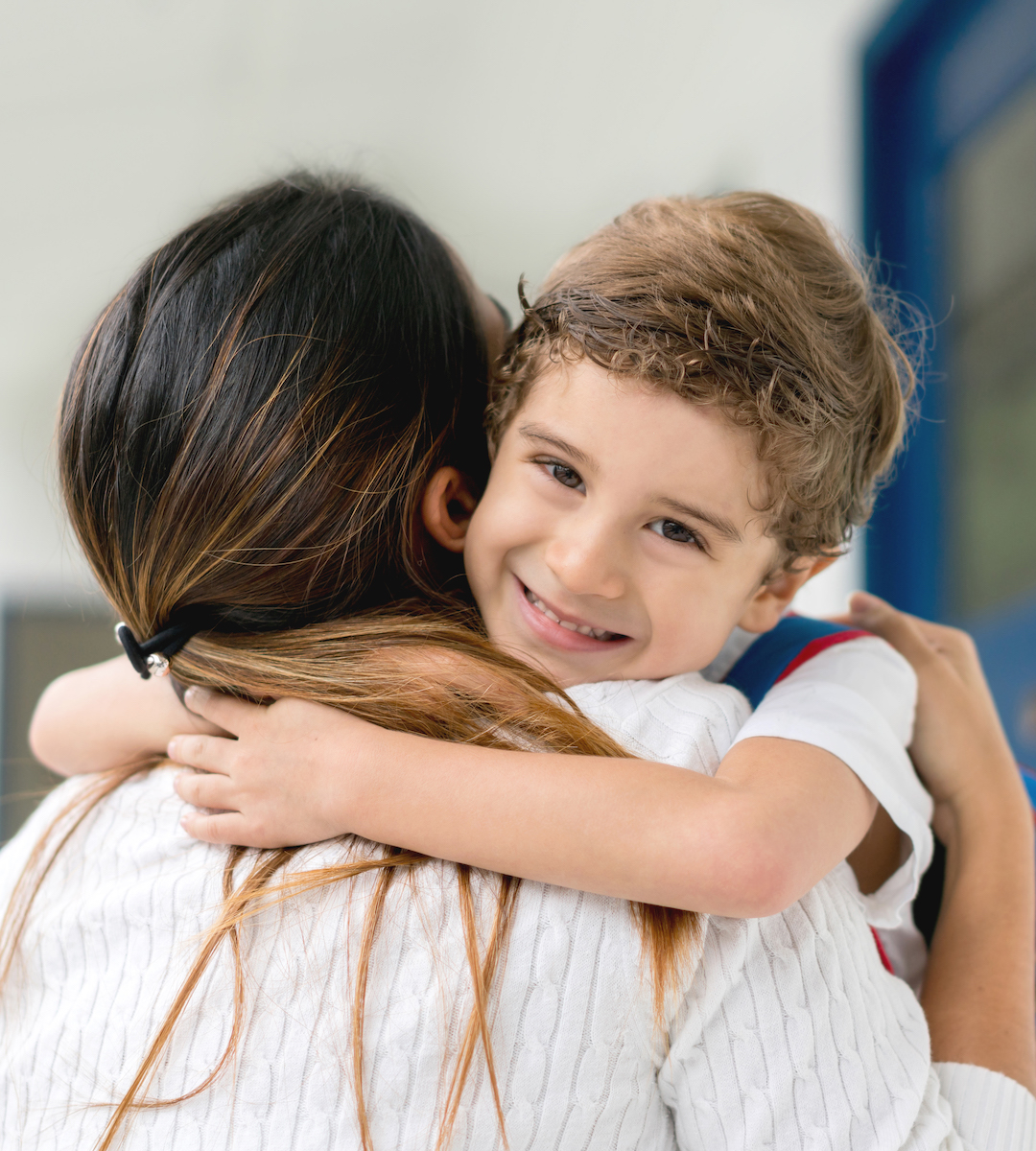 Boy at school hugging his teacher