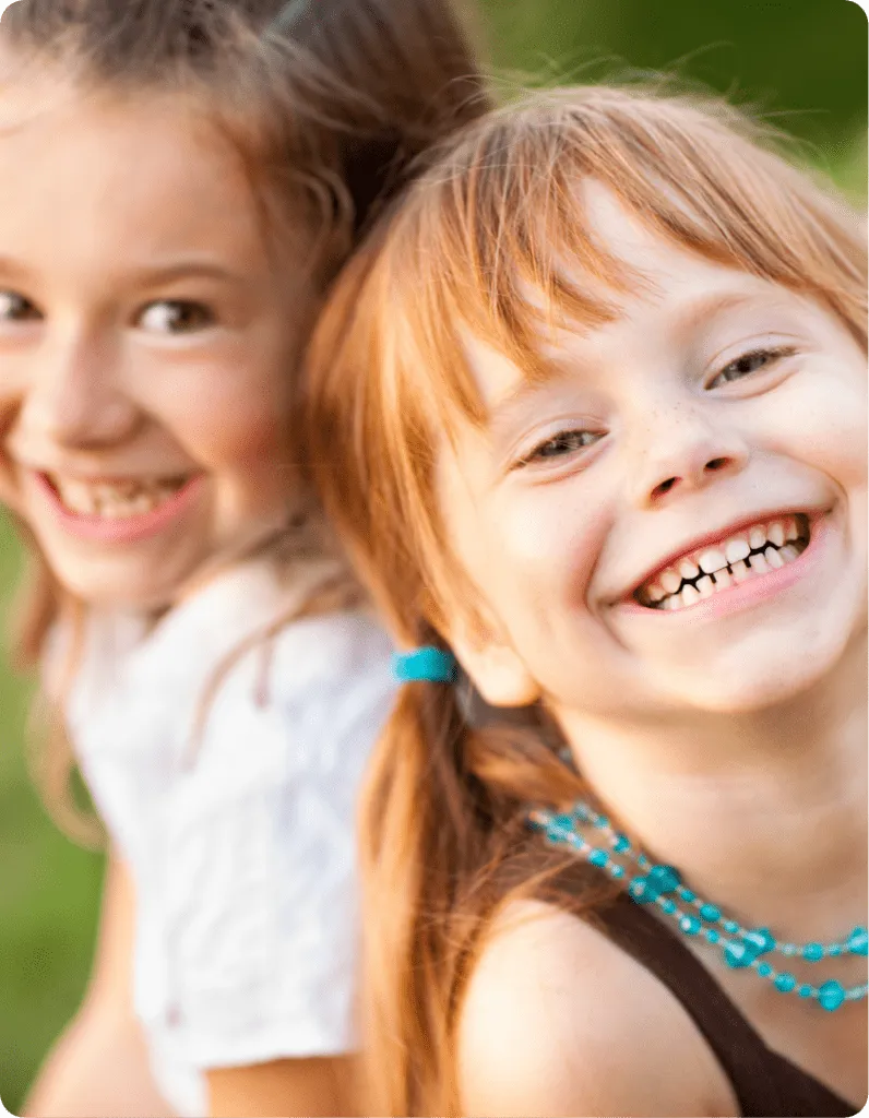 two young Caucasians in kindergarten smiling