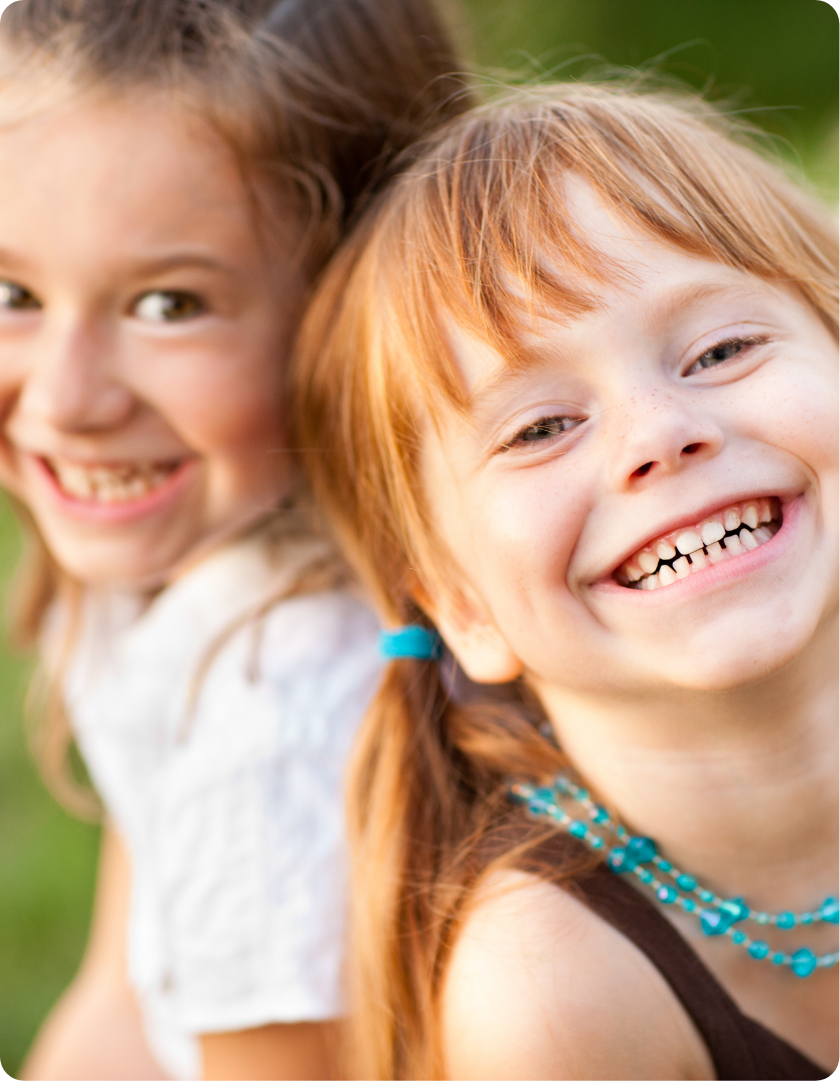two young Caucasians in kindergarten smiling