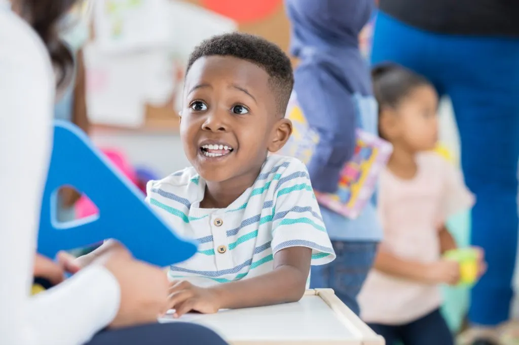 Excited little boy recognizes letter A at preschool.