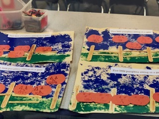 4 nearly identical art pieces depict pre-cut pumpkins sitting on green colored grass with blue sky above them. 