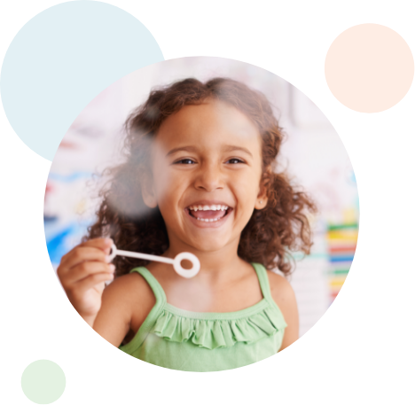 young girl laughing while making bubbles