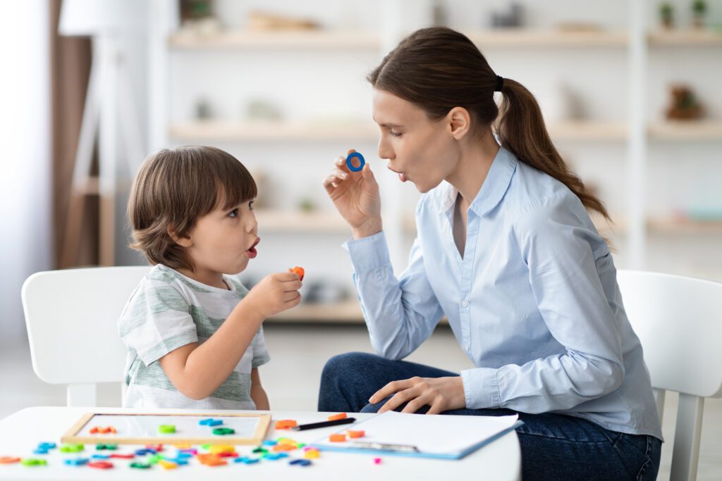 Young student and his teacher learning letters